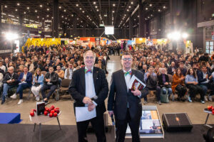 Perfetto! In tal caso, ecco una versione aggiornata dell’alt text SEO-oriented, tenendo conto che uno dei due potrebbe essere il fondatore Paolo Massobrio: Paolo Massobrio sul palco di Golosaria Milano 2025 durante una premiazione, di fronte a un pubblico numeroso nella fiera di Rho