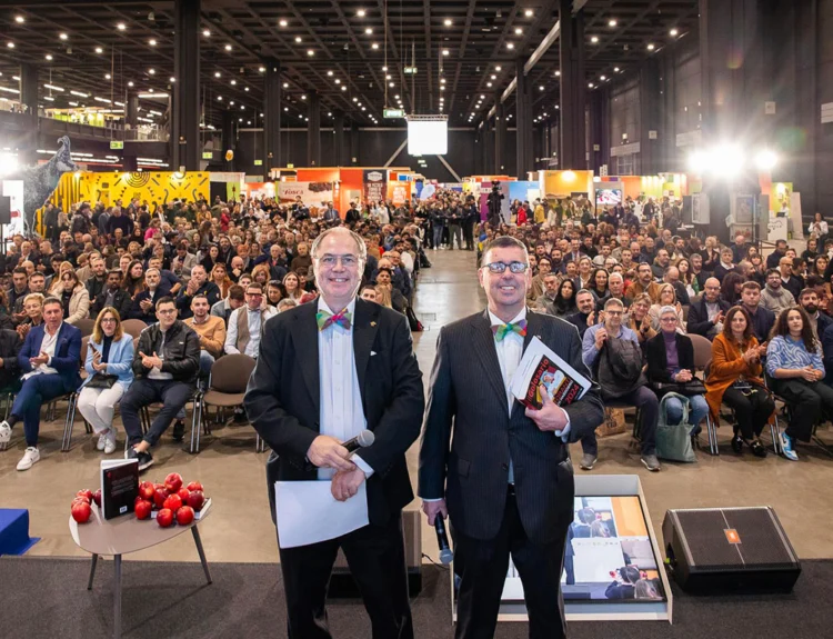 Perfetto! In tal caso, ecco una versione aggiornata dell’alt text SEO-oriented, tenendo conto che uno dei due potrebbe essere il fondatore Paolo Massobrio: Paolo Massobrio sul palco di Golosaria Milano 2025 durante una premiazione, di fronte a un pubblico numeroso nella fiera di Rho